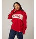 Flatlay image of 1796 red merino wool knitted jumper. red jumper with white stripe across the chest detailing 1796 in red. Woman wearing red jumper arms crossed across her chest. Woman wearing red jumper smiling crossing arms across her chest