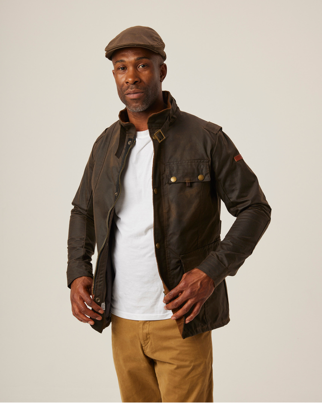 A flatlay image a brown Bexley Jacket. The jacket has full length sleeves and three pocket, two hand pockets at the hem on the jacket and one chest pocket. The jacket has a zip and popper close. The jacket has a funnel neck with a buckle strap to close the neck. There is a small union jack label on the right pocket. 