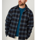 Flatlay image of a navy checked wool shirt with seven buttons down the center front fastening the collared shirt closed, the shirt has a slightly curved hem, the main base colour of the shirt is navy with the check pattern being a lighter shade of grey/blue.